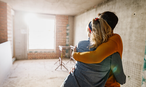 Happy couple pointing to a home renovation.