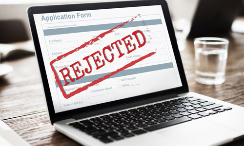 An application on a computer screen with the words REJECTED across it in red.