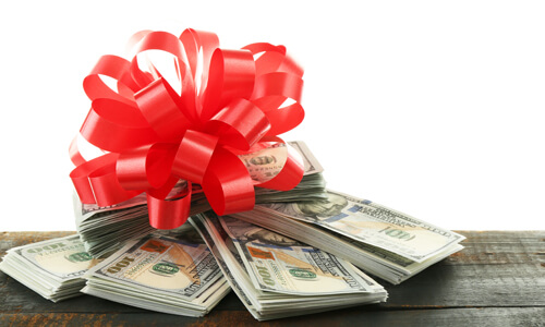 Bundles of cash with a holiday bow on top.