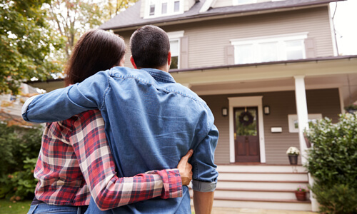 Man and woman looking at their new home.