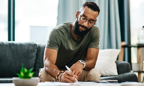 Man sitting on couch confidently handling his finances and inheritance.