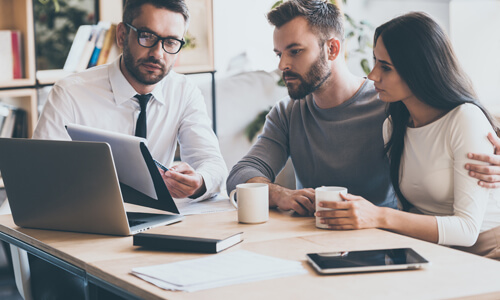 Couple sitting with mortgage lender, getting ready to buy a home.