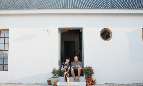 Couple sitting outside of their rental home.