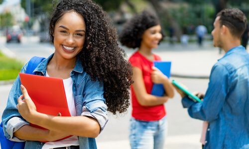 Smiling college student looking at the camera, on campus.