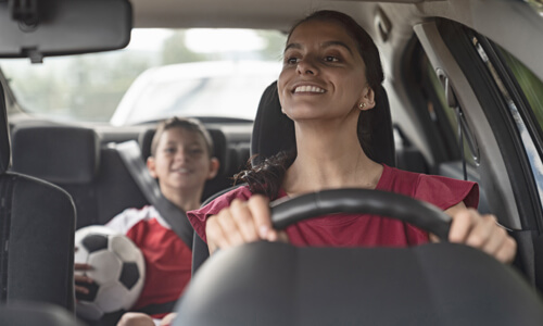 Mother driving young son to soccer practice.