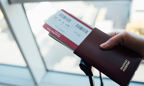 Closeup of airline tickets in a person's passport (airline tickets are a great buy in September.)