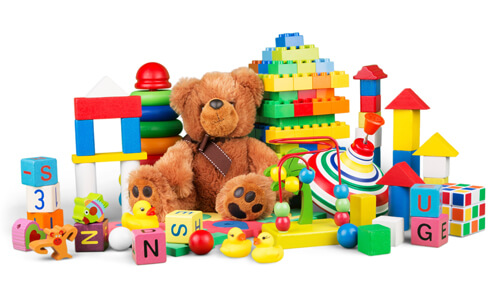 Childrens toys (teddy bear, brightly colored blocks and rings) against a white background.