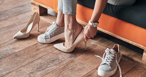 Closeup of woman trying on high-heel shoes, shopping.