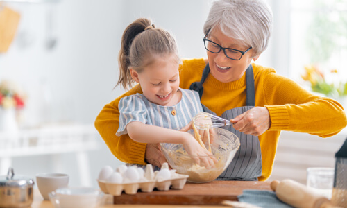 Grandmother in retirement baking with her granddaughter.
