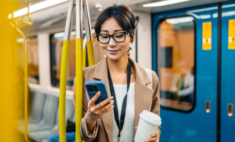 Woman on train checking her bank account on mobile phone
