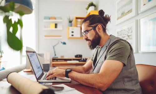Freelancer doing his taxes at home at his desk.