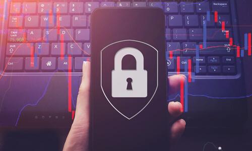 Phone displaying padlock, computer keyboard in background; concept of mobile phone security/safety.