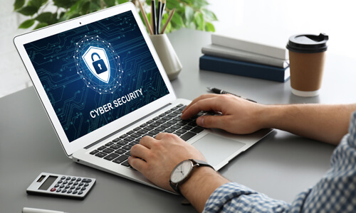 Closeup of computer screen and keyboard, with "Cybersecurity" written on monitor.