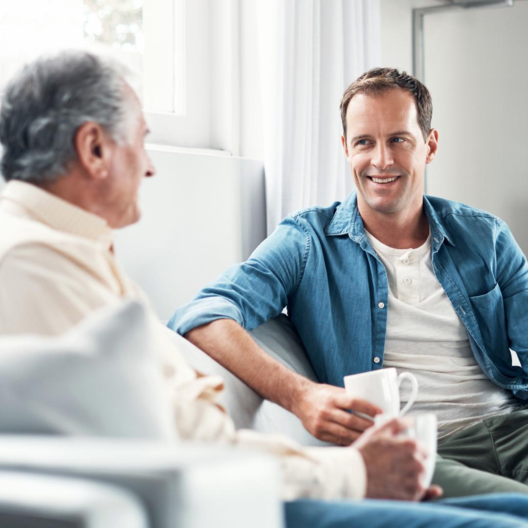 Man speaking with elderly father about finances.