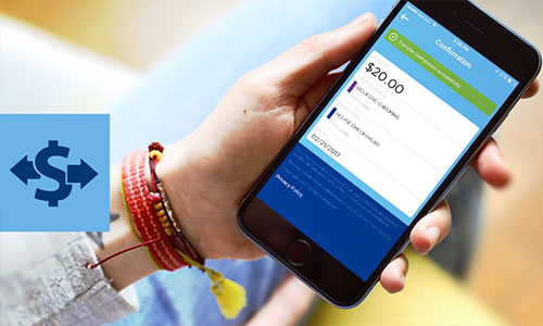 Closeup of hand holding mobile device displaying Quorum mobile banking app and transfer being initiated between checking accounts.