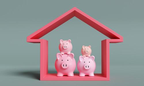Toy pigs in house, illustrating concept of a piggyback mortgage.