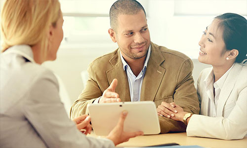 Couple sitting with bank manager discussing opening a savings account.