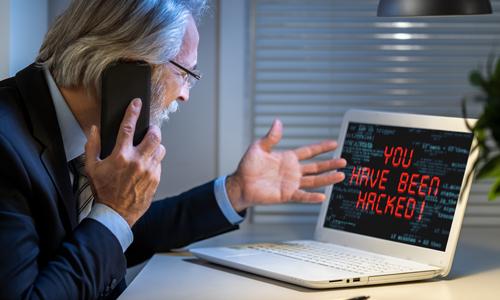 Man on phone with technical support scammer after receiving popup on his computer.